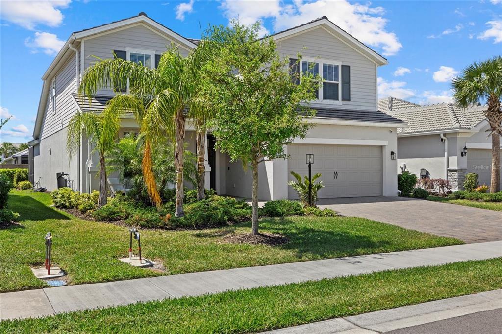 3508 Anchor Bay Trail Lakewood Ranch, FL 34211 - Photo 48 of 74 a front view of a house with a yard and potted plants