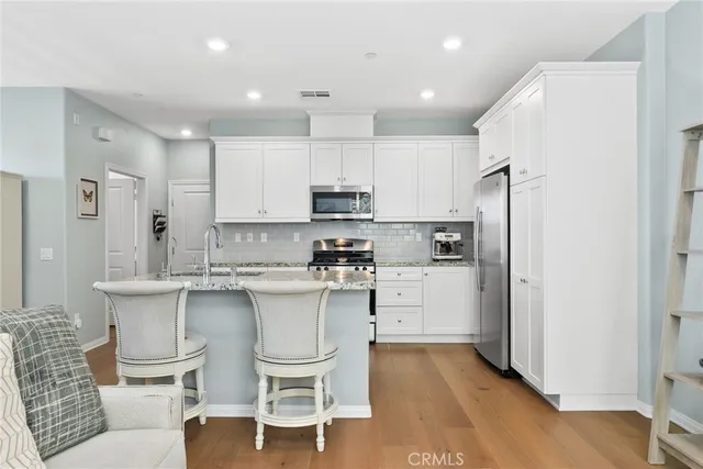 a kitchen with white cabinets and stainless steel appliances