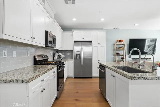 a kitchen with stainless steel appliances granite countertop a sink stove and refrigerator