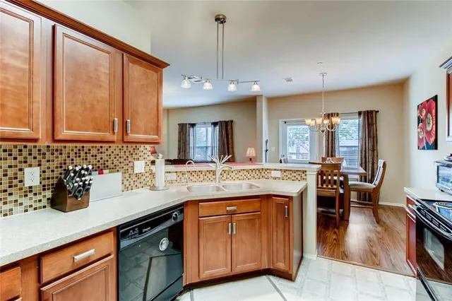 a kitchen with cabinets a counter and chairs in it
