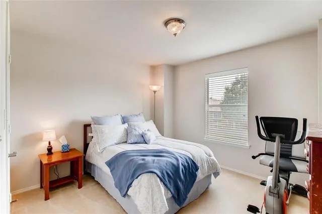 a bedroom with a bed and a table lamp