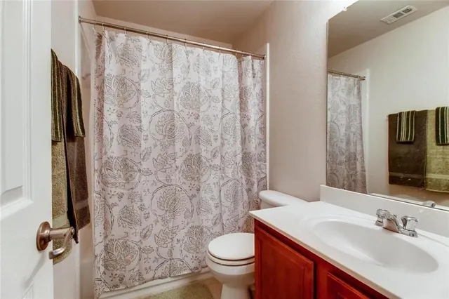 a bathroom with a granite countertop toilet sink and a mirror