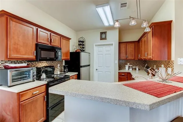 a kitchen with stainless steel appliances a stove microwave and refrigerator