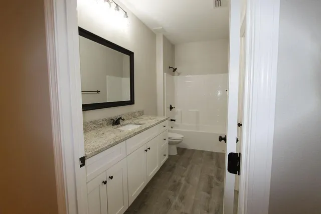 a bathroom with a double vanity sink and mirror with shower