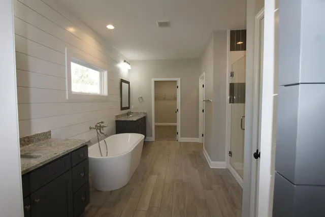 a bathroom with a granite countertop sink a toilet a shower and a mirror