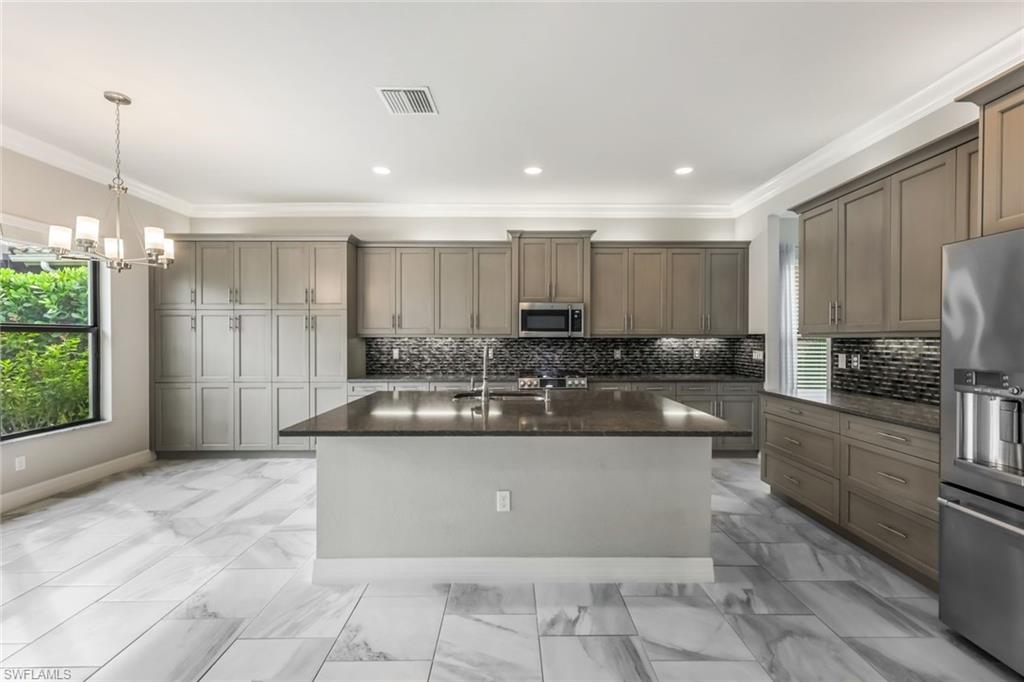 4609 Azalea Drive Naples, FL 34119 - Photo 13 of 45 a kitchen with a sink and cabinets