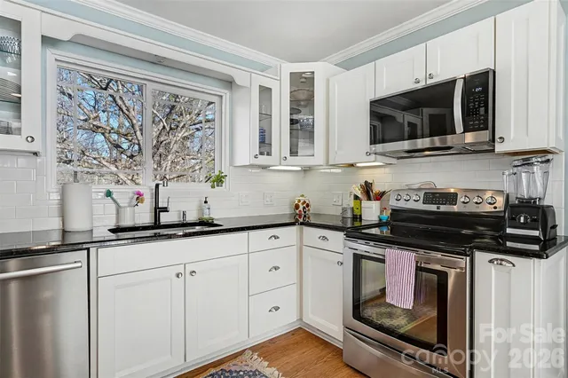 a kitchen with stainless steel appliances granite countertop a sink and a stove top oven
