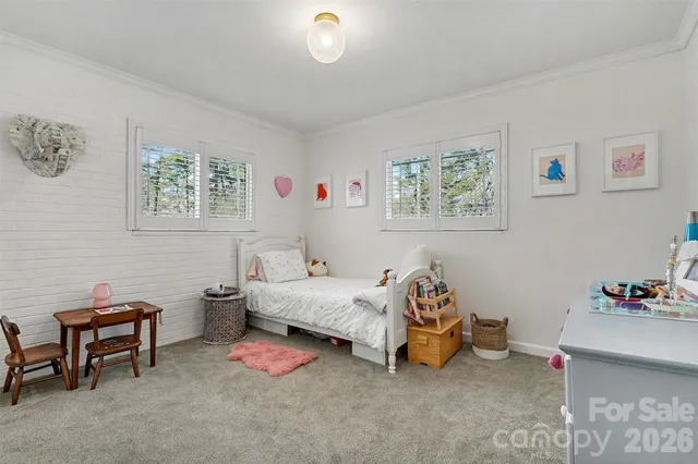 a bedroom with furniture and a large window