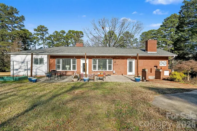 a view of a house with a yard and sitting area