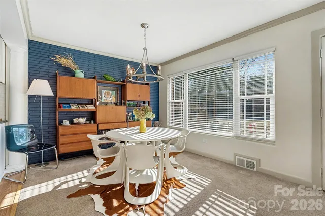 a dining room with furniture a chandelier and wooden floor