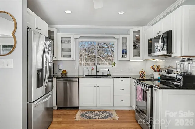 a kitchen with stainless steel appliances granite countertop a refrigerator stove and sink