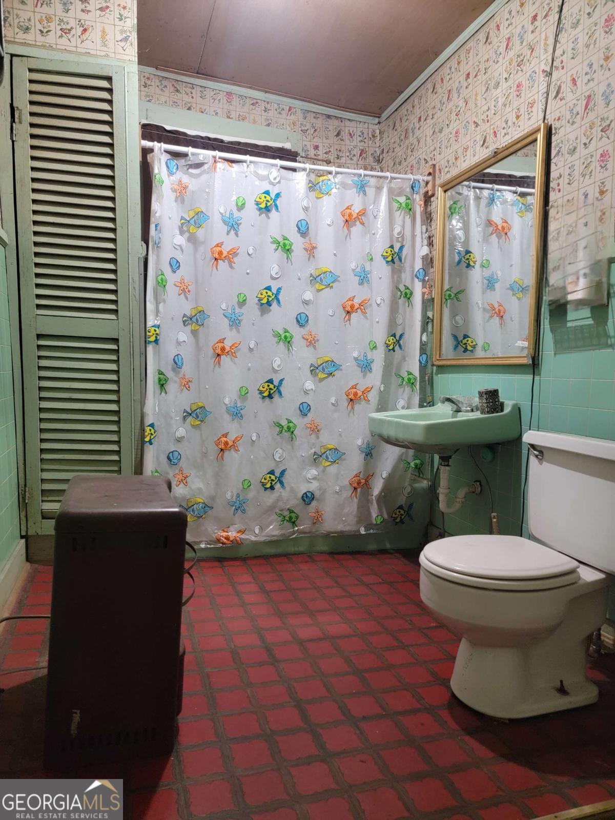 346 South Oliver Street Elberton, GA 30635 - Photo 24 of 52 a bathroom with a toilet and a shower curtain