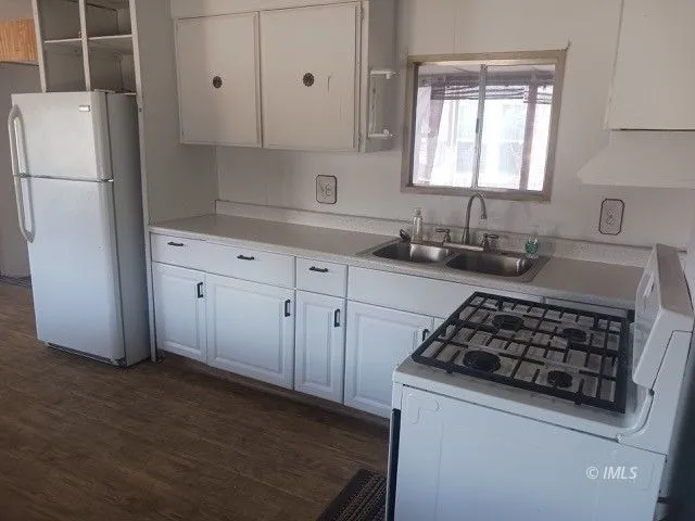 a kitchen with granite countertop a sink stove and refrigerator