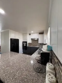 a large white kitchen with a stove and a sink