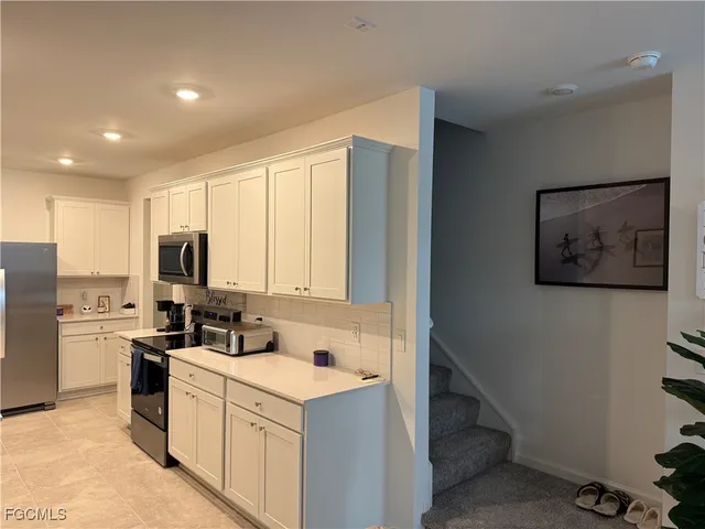 a kitchen with sink a microwave and cabinets