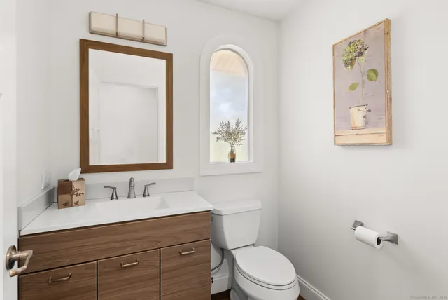 a bathroom with a toilet sink and mirror