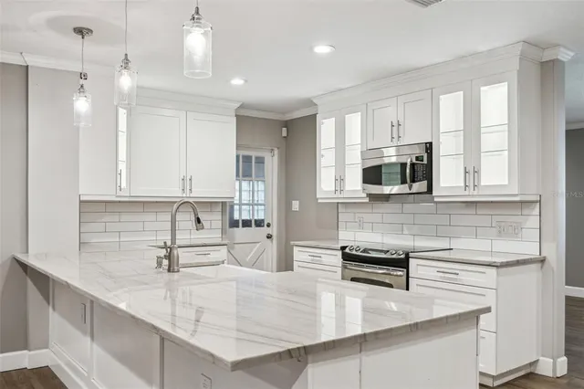 a kitchen with stainless steel appliances a sink a stove and microwave