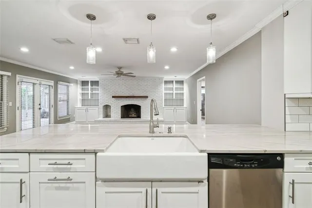 a kitchen with kitchen island a sink stainless steel appliances and white cabinets