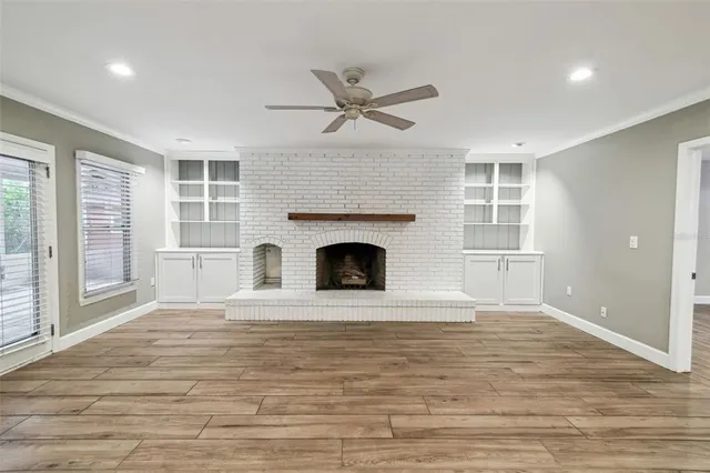 a view of an empty room with a fireplace and a window