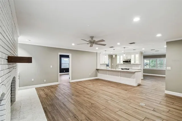 a large kitchen with kitchen island a stove a sink dishwasher and a refrigerator with wooden floor