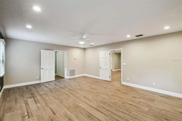a view of an empty room with wooden floor