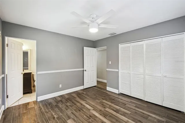 an empty room with wooden floor and white walls