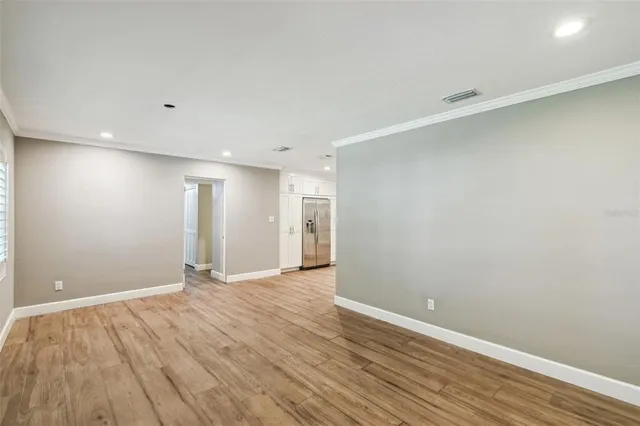 a view of an empty room with wooden floor