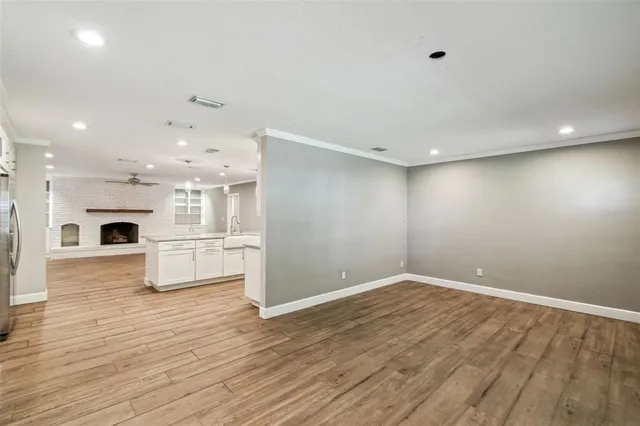 a view of empty room with wooden floor and fireplace