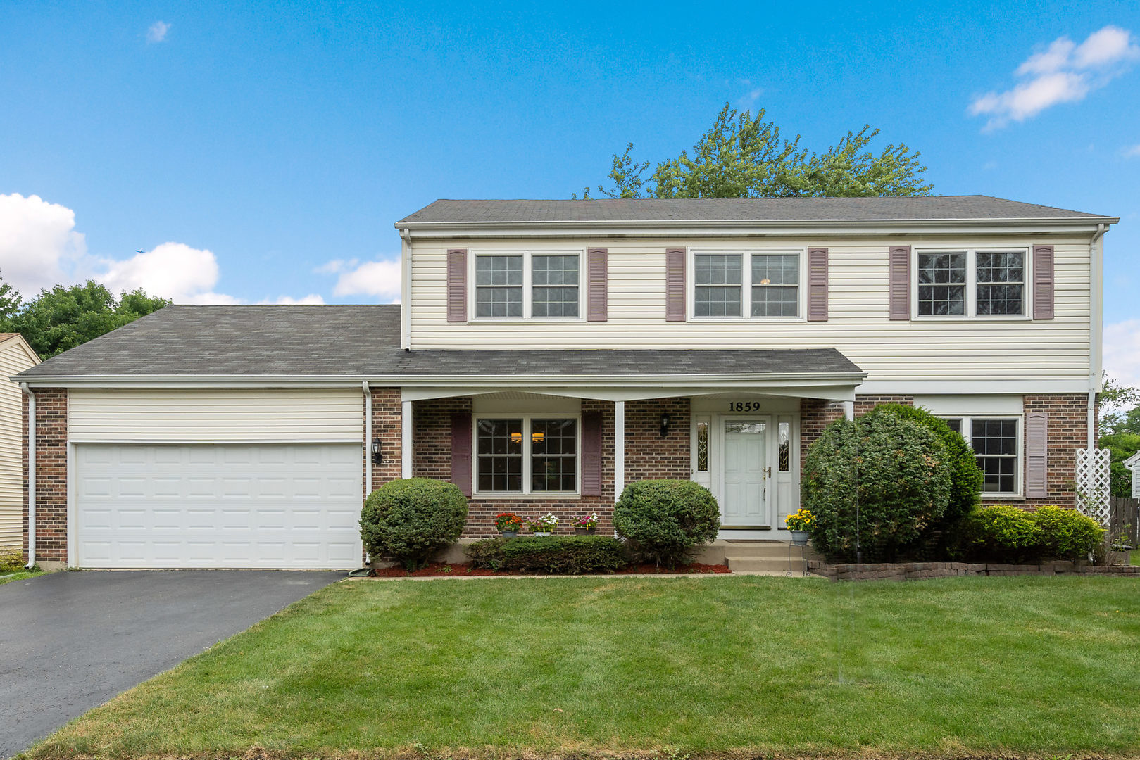 a front view of a house with a yard and garage