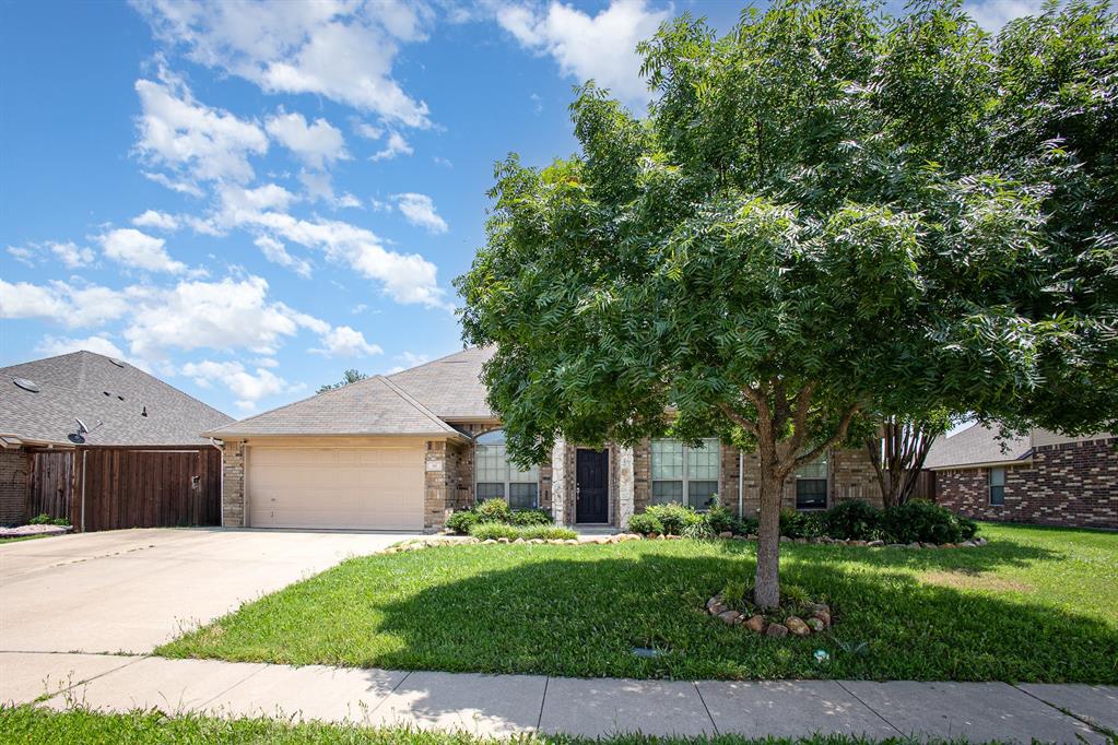 a front view of a house with a yard and a garage