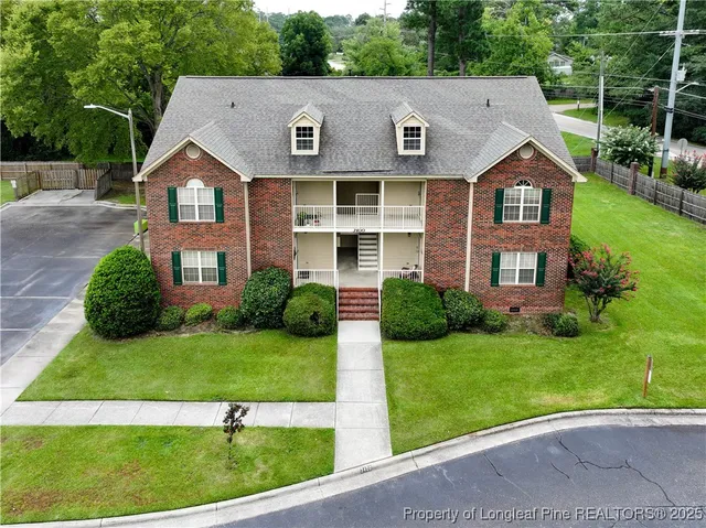 a aerial view of a brick house next to a yard