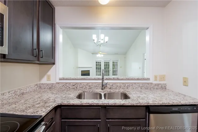 a kitchen with granite countertop stainless steel appliances sink and cabinets