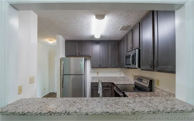 a kitchen with stainless steel appliances granite countertop a refrigerator and a sink