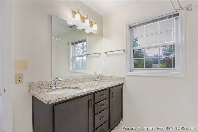a bathroom with a granite countertop sink a large mirror and a shower