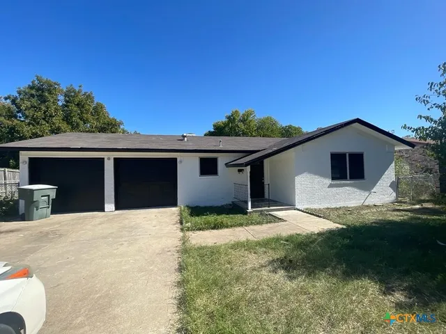 a view of house with yard and car parked