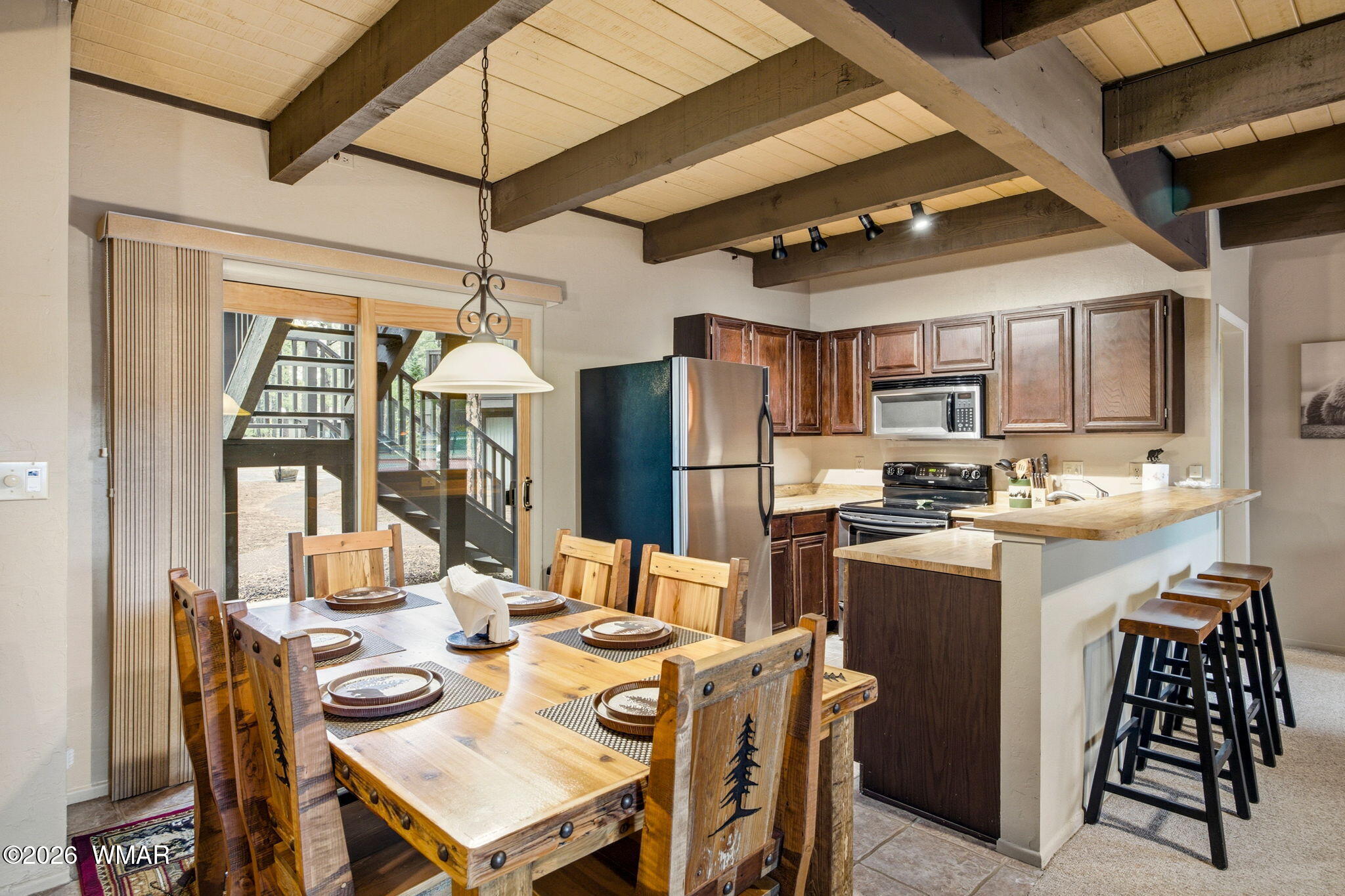 4563 Resort Loop Pinetop, AZ 85935 - Photo 3 of 21 a kitchen with stainless steel appliances kitchen island granite countertop a dining table chairs and a refrigerator
