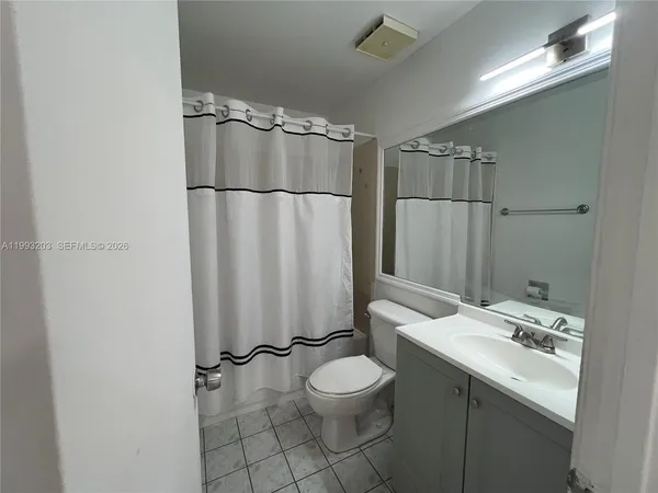 a bathroom with a shower and white walls