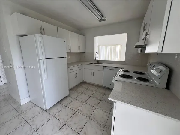 a kitchen with a refrigerator a stove a sink and a window