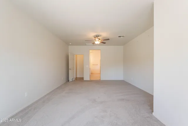 a view of an empty room with a chandelier fan