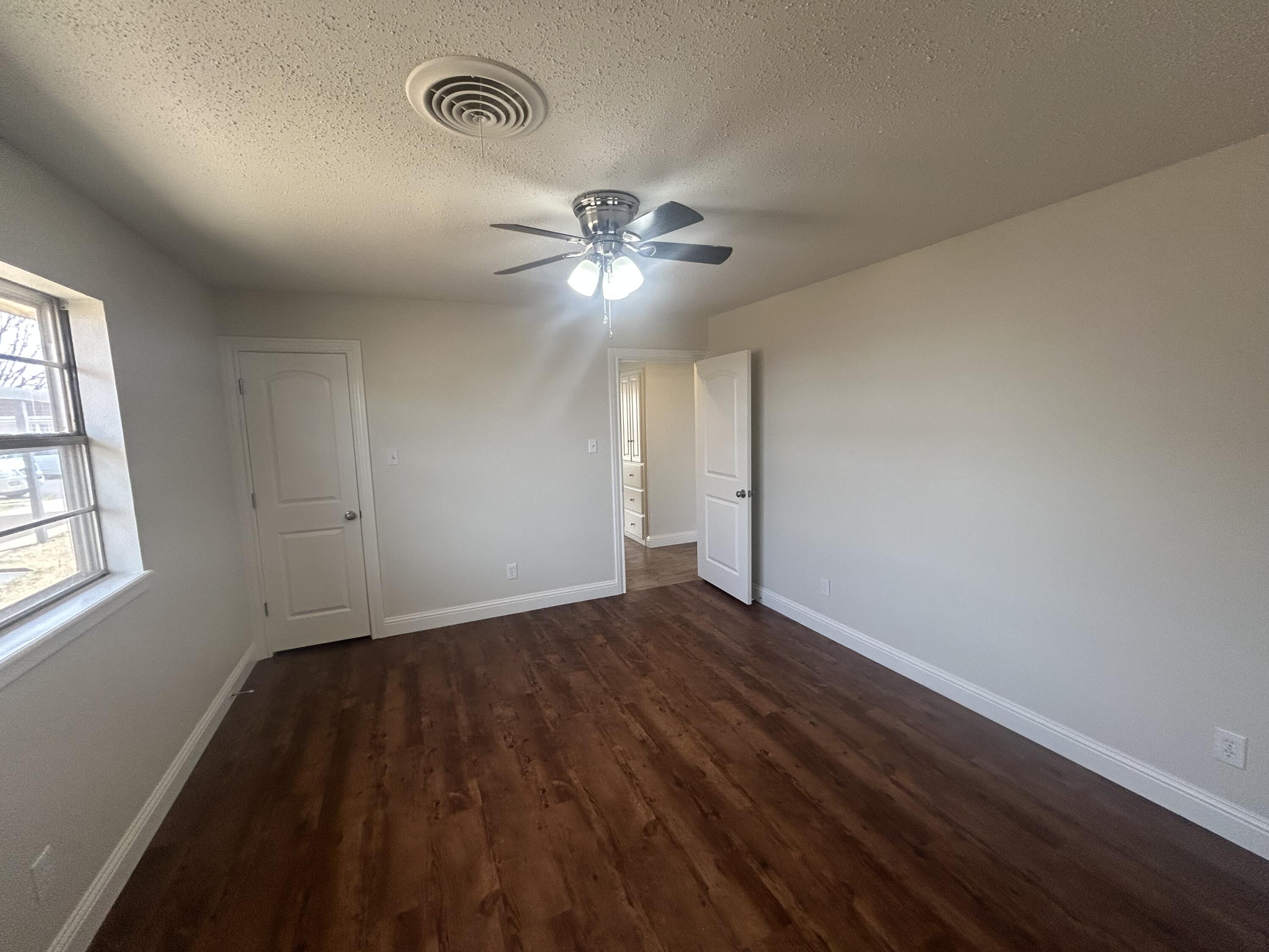 111 Bobby Street Levelland, TX 79336 - Photo 11 of 25 wooden floor in an empty room with a window