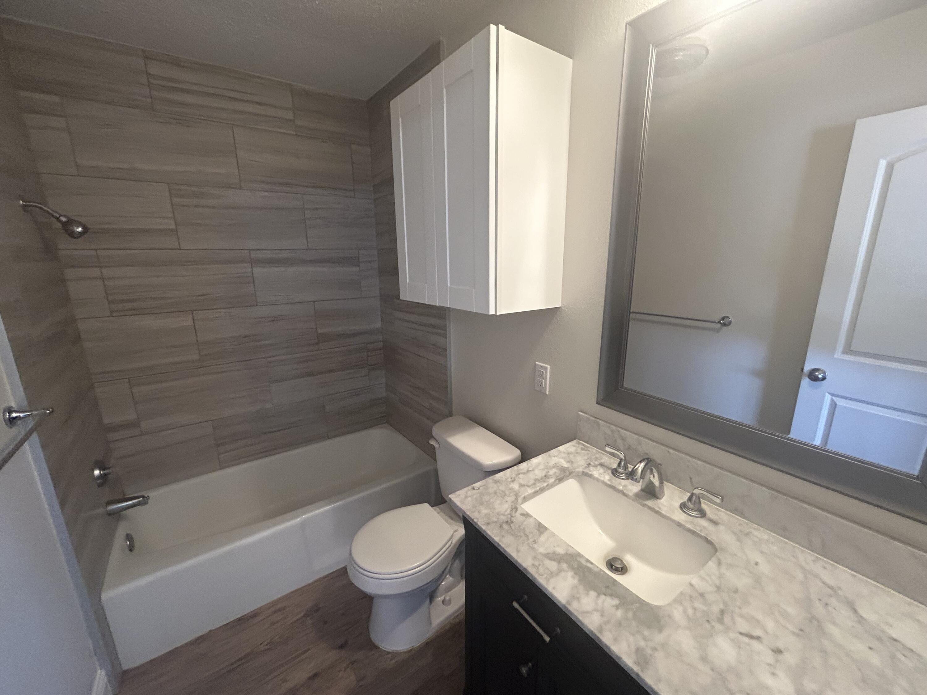 111 Bobby Street Levelland, TX 79336 - Photo 12 of 25 a bathroom with a granite countertop sink toilet and shower