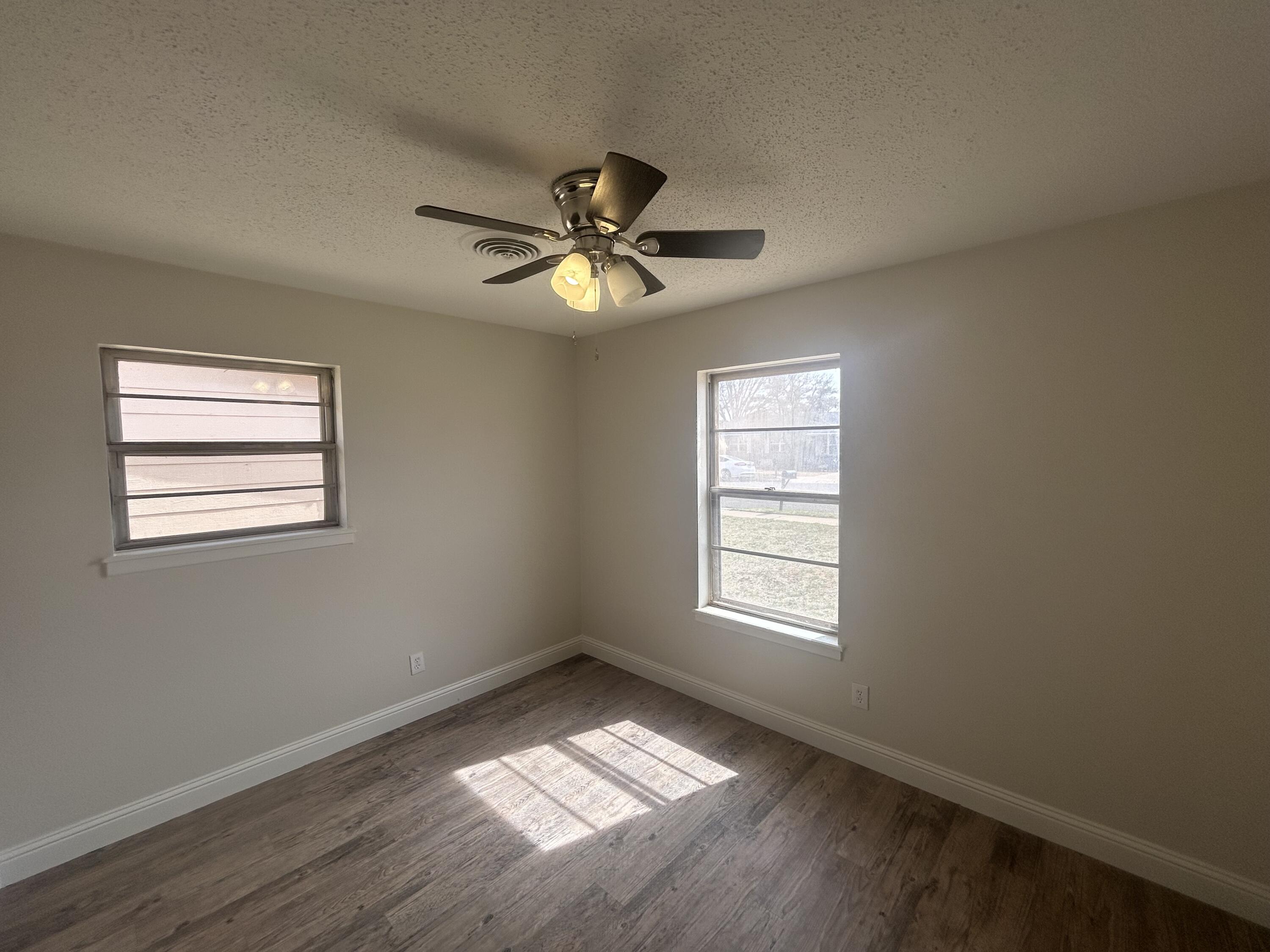 111 Bobby Street Levelland, TX 79336 - Photo 15 of 25 a view of an empty room with a window and wooden floor