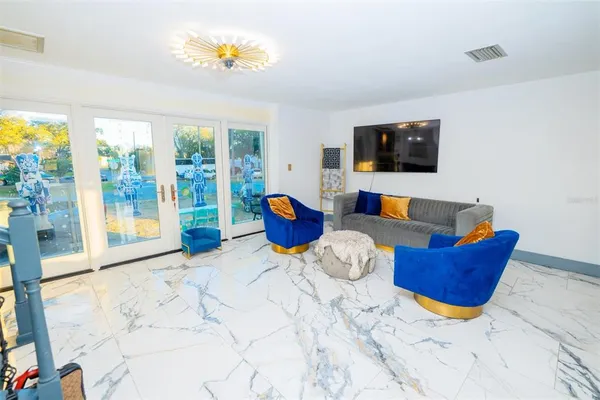 a kitchen with stainless steel appliances kitchen island granite countertop a table chairs and a refrigerator