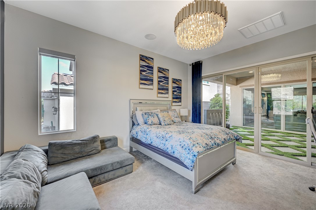 3943 Reyes Avenue Las Vegas, NV 89141 - Photo 45 of 95 Step into comfort with soft carpeting and natural light, complemented by a sparkling chandelier.