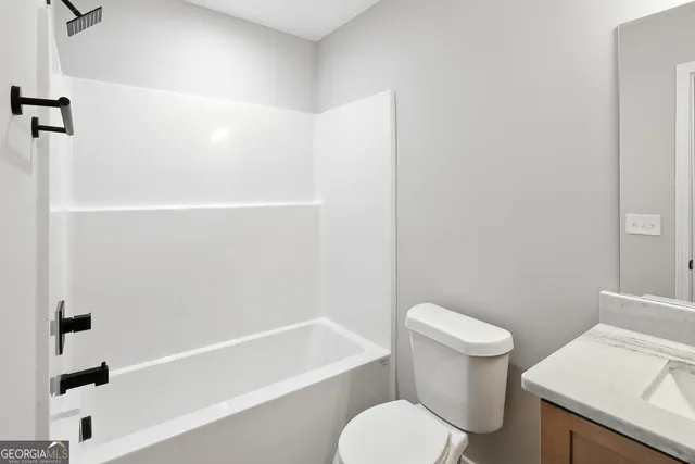 a white toilet and tub sitting next to a bathroom sink