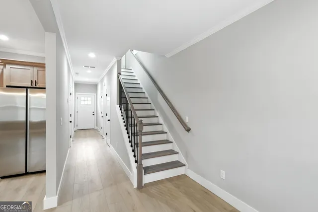 a view of a hallway with staircase and white walls