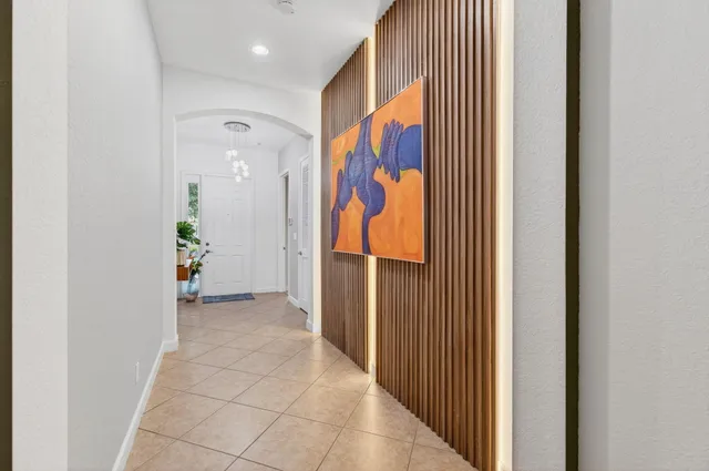 a living room with furniture and a flat screen tv with kitchen view