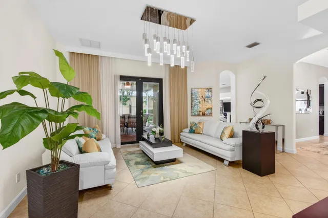 a living room with furniture kitchen view and a large window