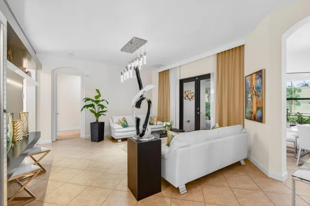 a living room with furniture kitchen view and a large window