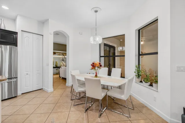 a dining room with furniture and large windows